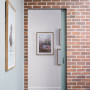hallway, entranceway, white hallway, grey door, brick interior wall, brick feature wall