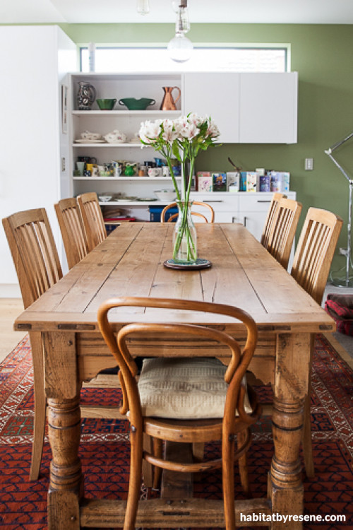 dining room, wooden dining table and chairs, green feature wall, green kitchen