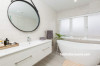 white bathroom, freestanding bath, hanging mirror, white tiles, curved bath 